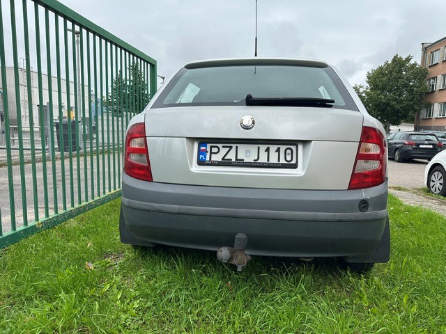 Widok na tył auta. Srebra klapa z tablicą rejestracyjną, zderzak oraz zamontowany hak holowniczy.