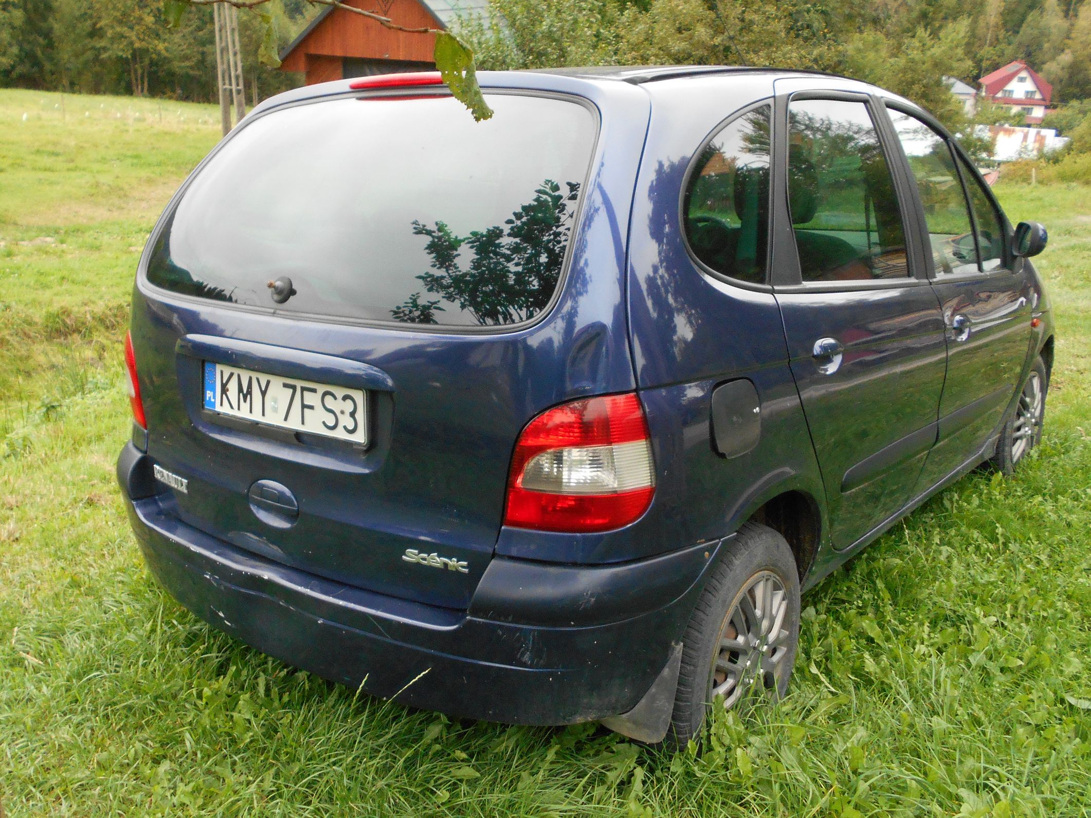 Niebieski samochód Renault Scenic z polskimi tablicami rejestracyjnymi.