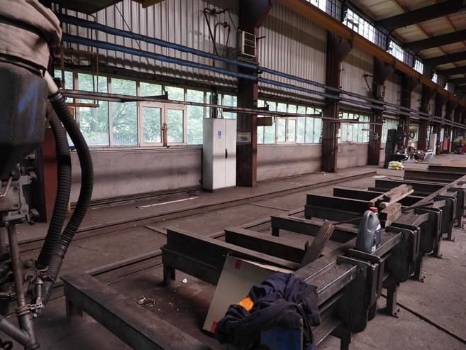 Przemysłowa maszyna do spawania automatycznego- megaukład, widoczne torowisko oraz zestaw metalowych podpór.