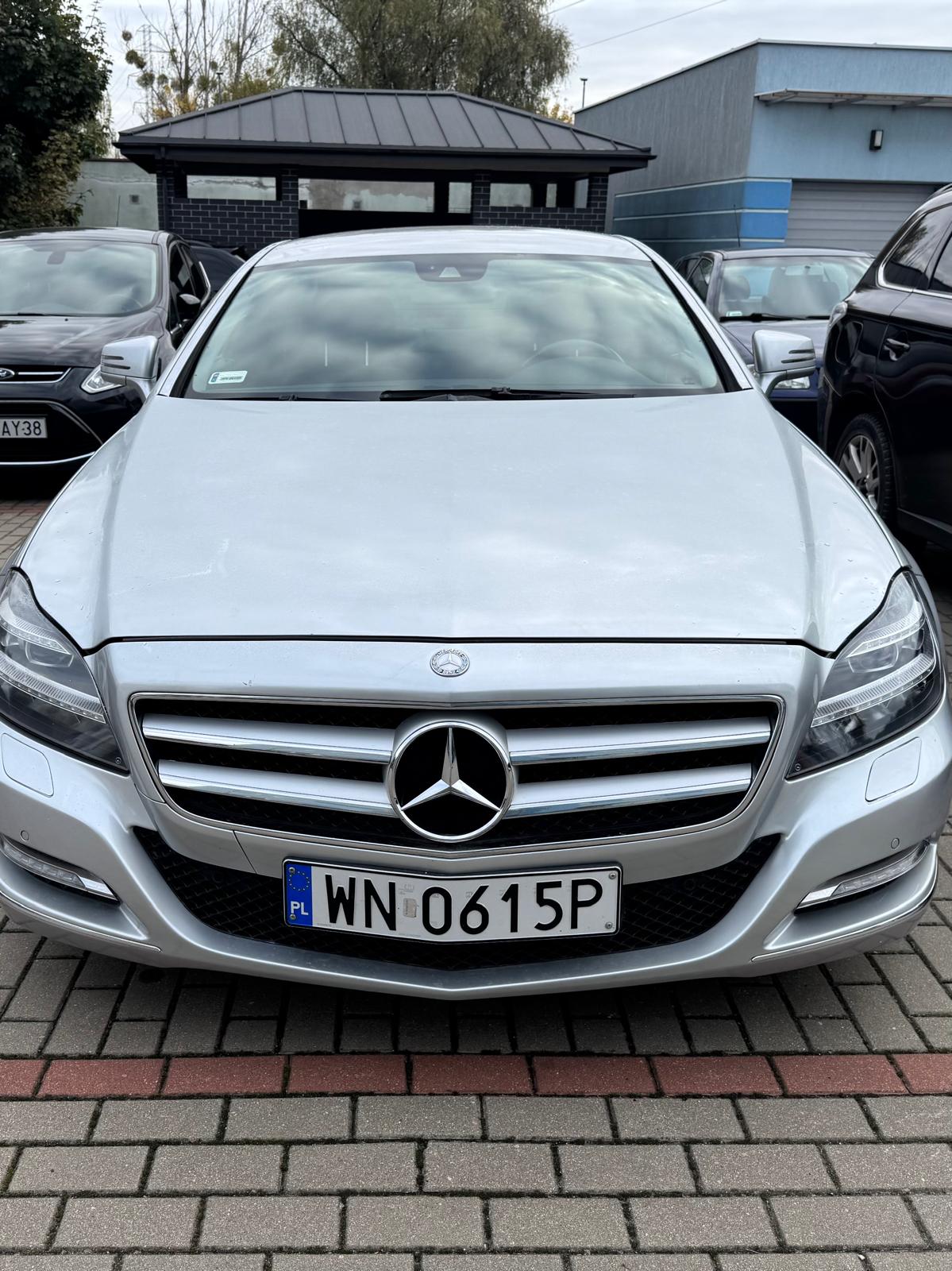 Przód srebrnego Mercedesa-Benz CLS z widoczną tablicą rejestracyjną.