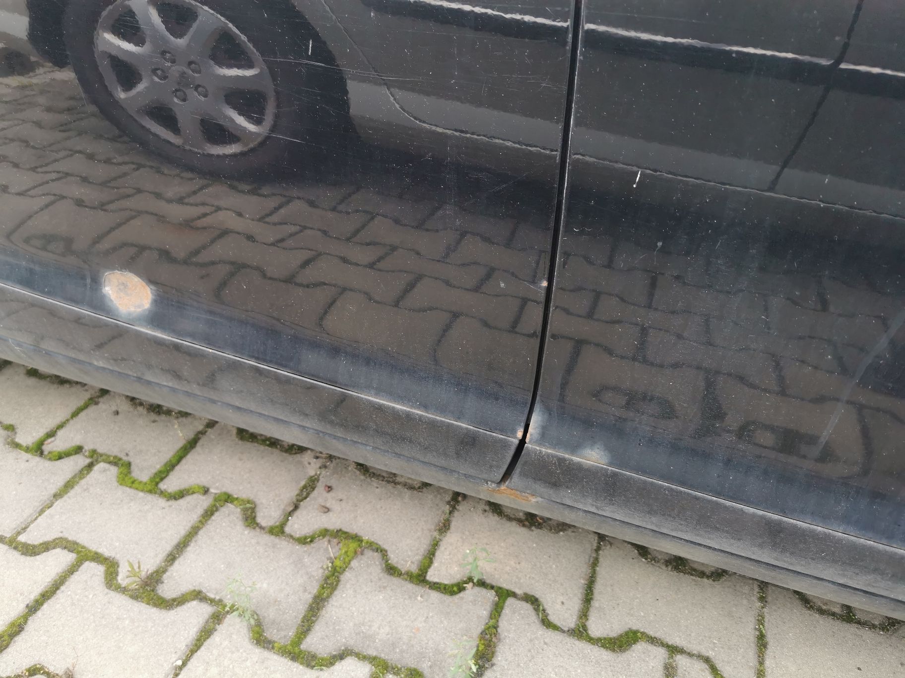 Prawe tylne drzwi z widoczną rdzą oraz uszkodzeniem.