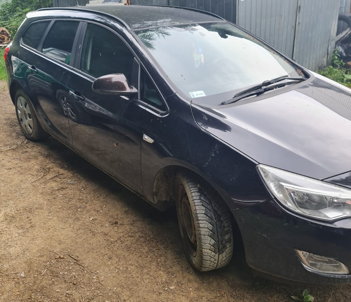 Prawy bok granatowego pojazdu marki Opel Astra.