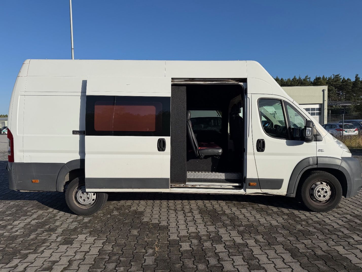 Biały Fiat Ducato, ujęcie prawego boku pojazdu.