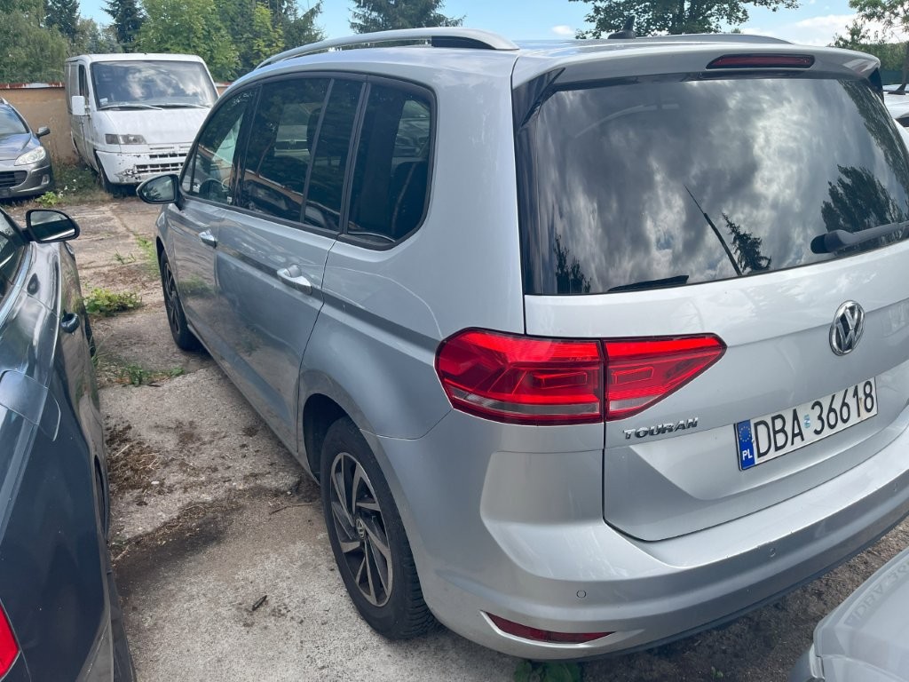 Tył pojazdu od strony lewej z widocznymi lampami i tablicą rejestracyjną