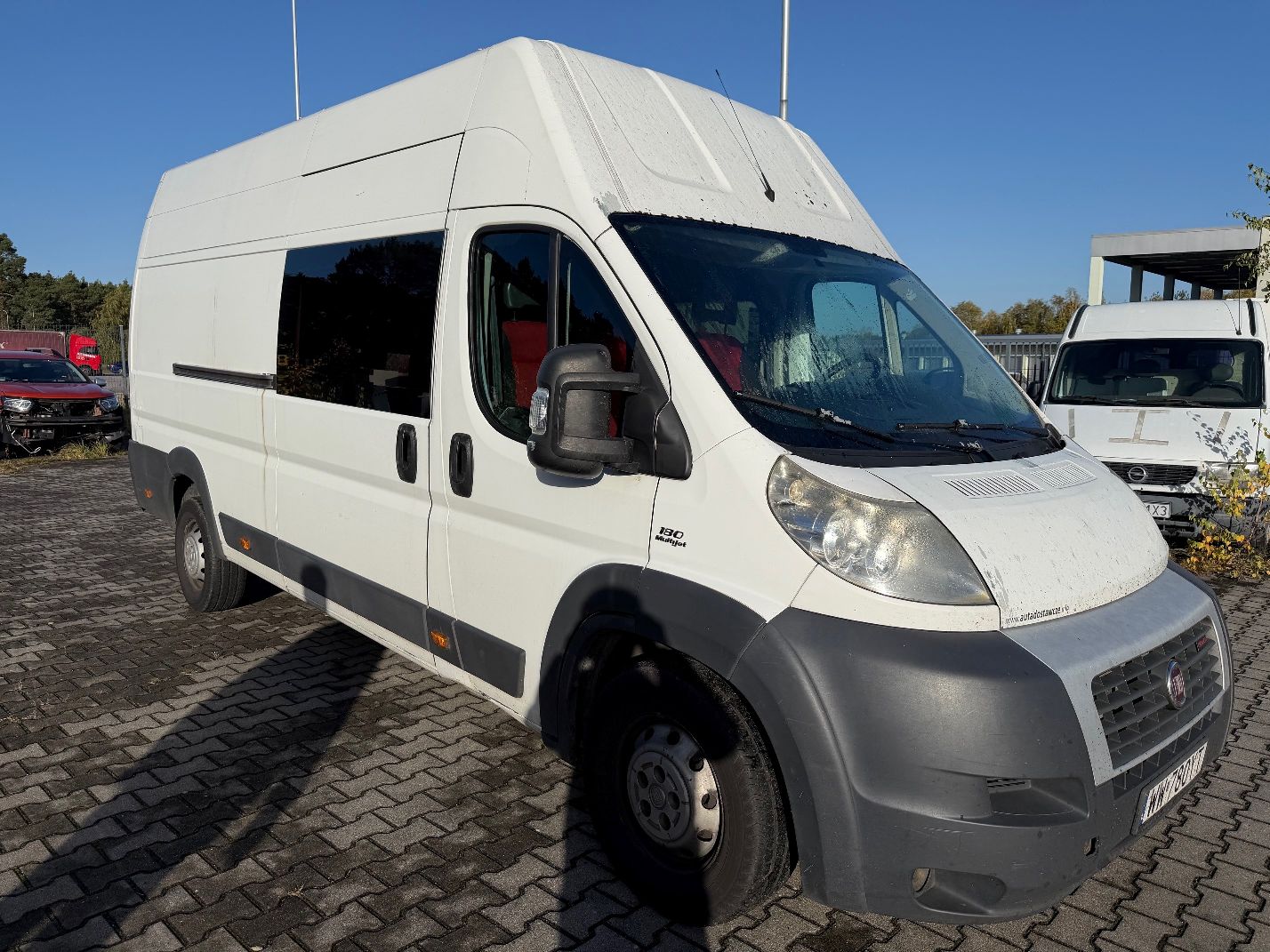 Biały Fiat Ducato, ujęcie prawej strony i przodu pojazdu.