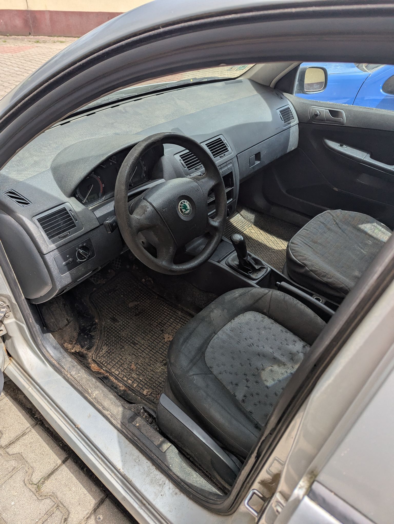 Wnętrze samochodu Skoda Fabia od strony kierowcy, tapicerka i dywaniki są zabrudzone, co wskazuje na intensywne użytkowanie