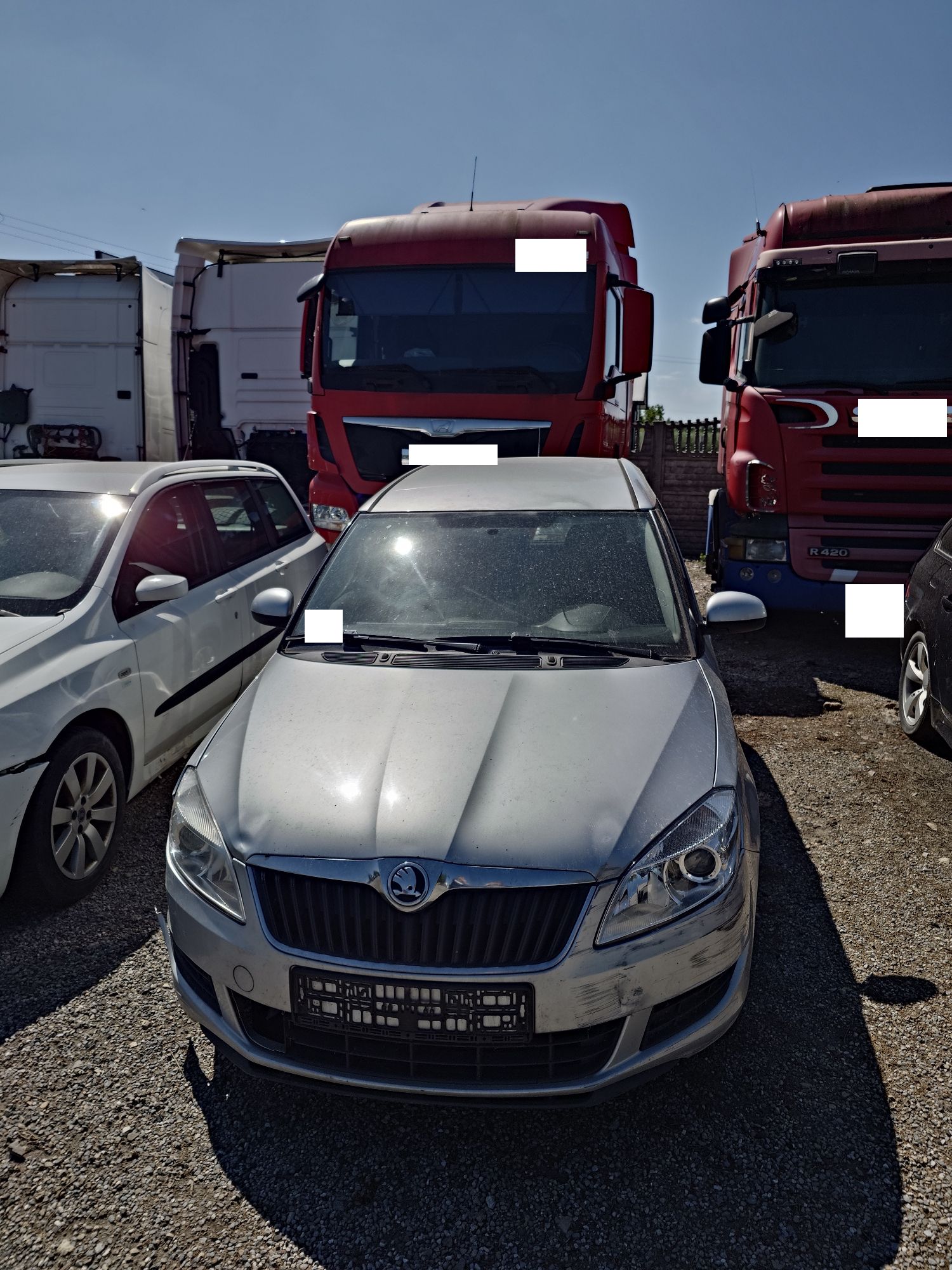 Srebrna Skoda Roomster, widoczny uszkodzony zderzak, rozbity reflektory, wgniecenia maski silnika