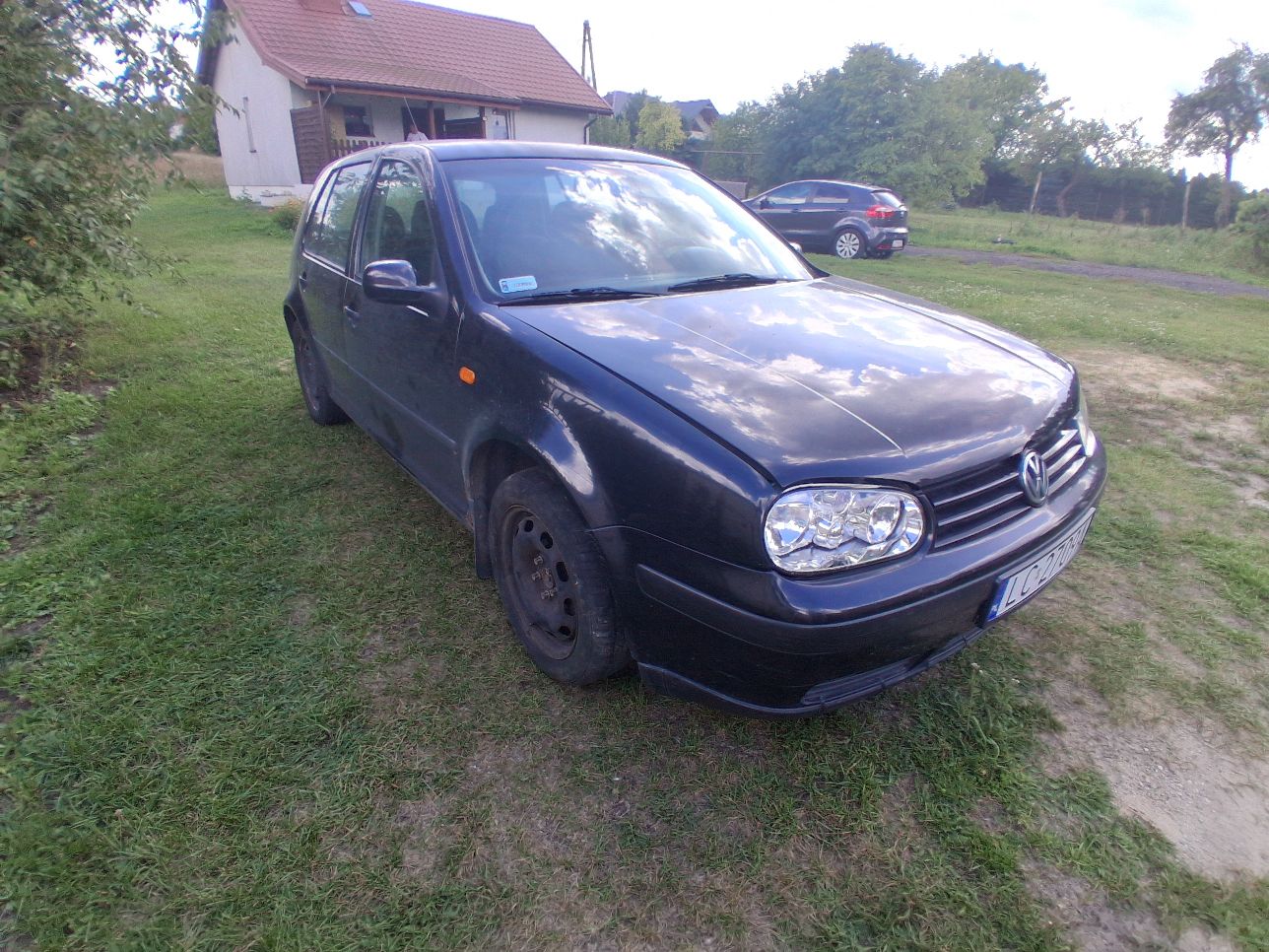 Samochód osobowy marki Volkswagen koloru granatowego, widok z przodu.