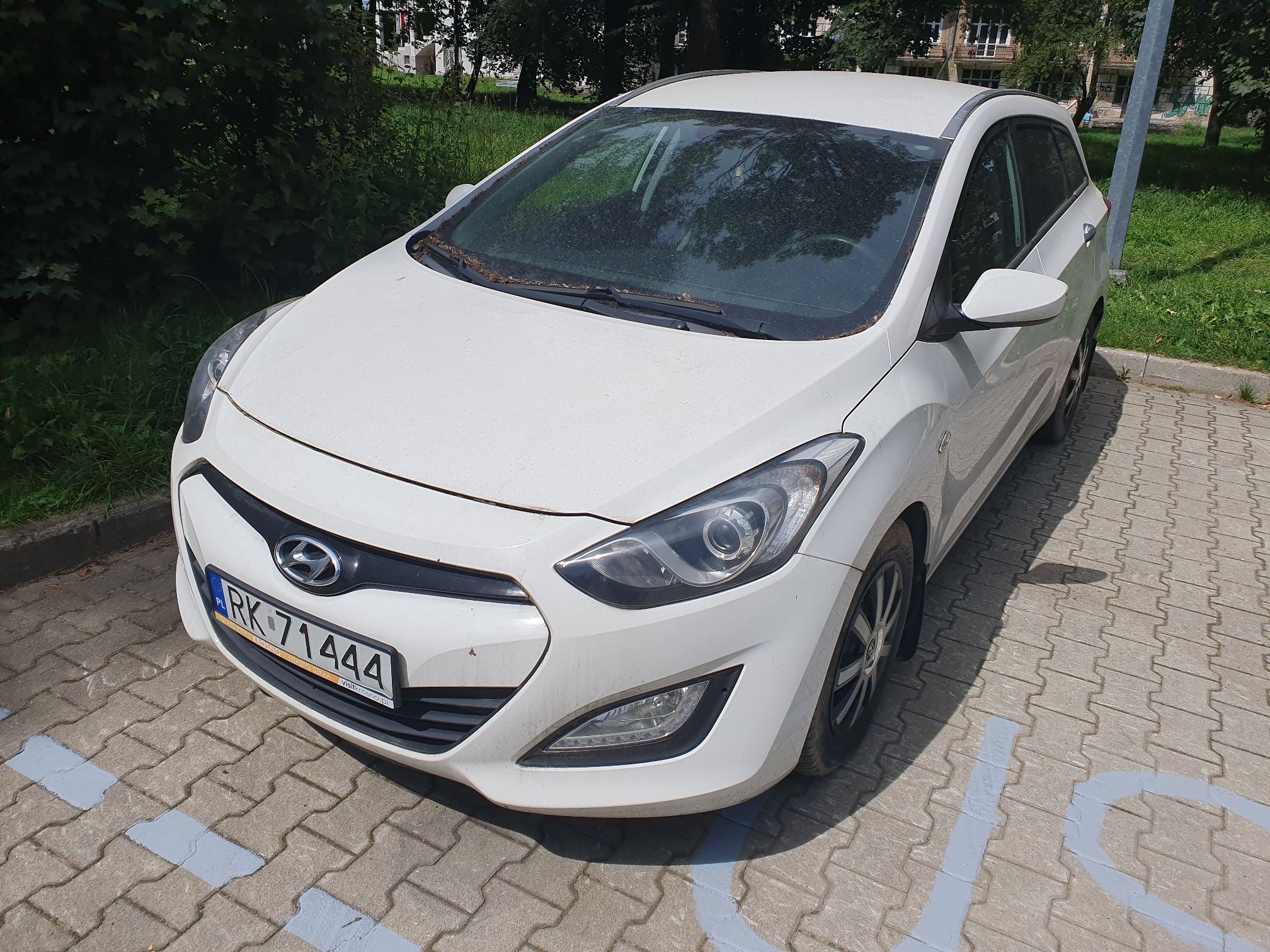 Hyundai i30 kombi, biały, lewy przód.