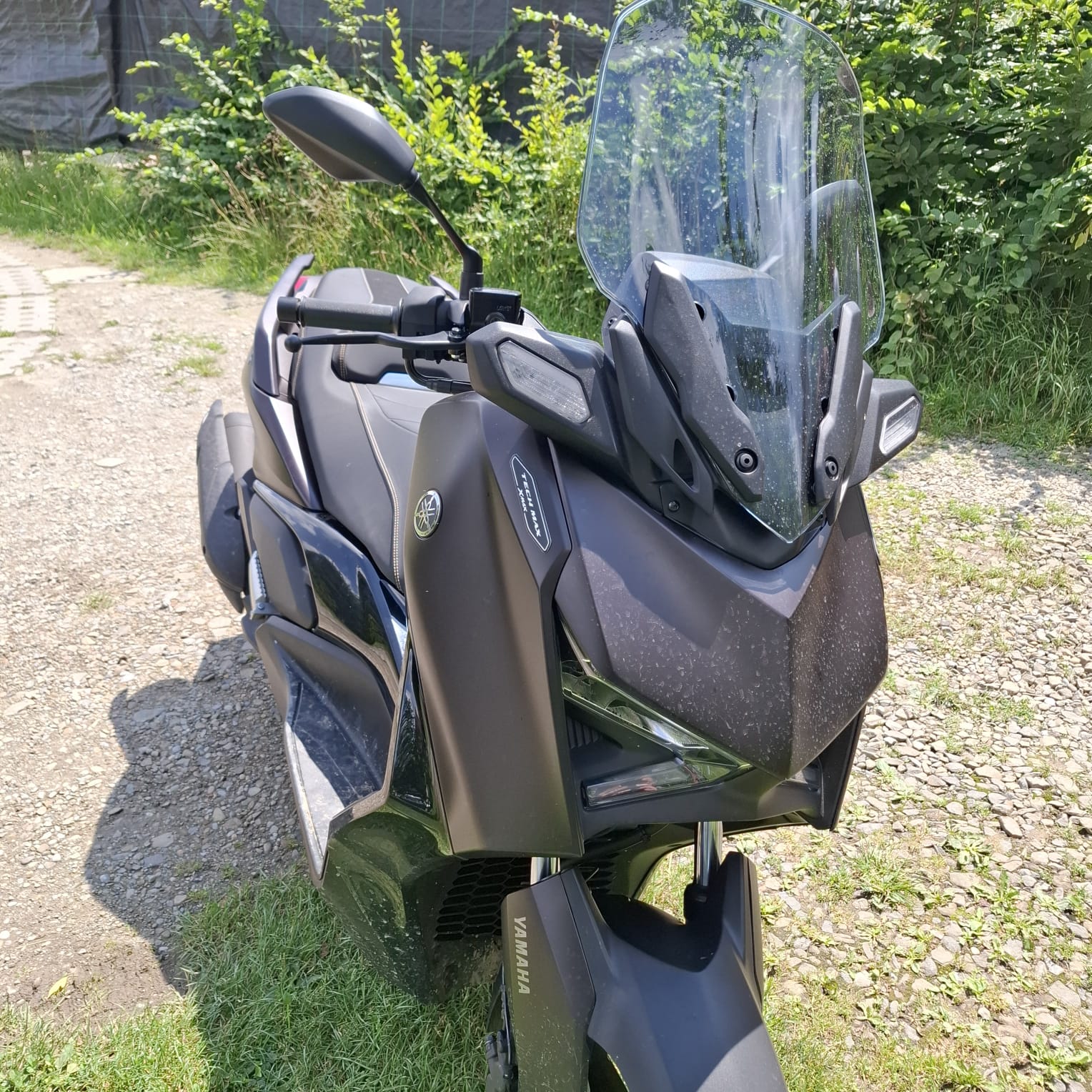 Czarny skuter Yamaha z dużą szybą.