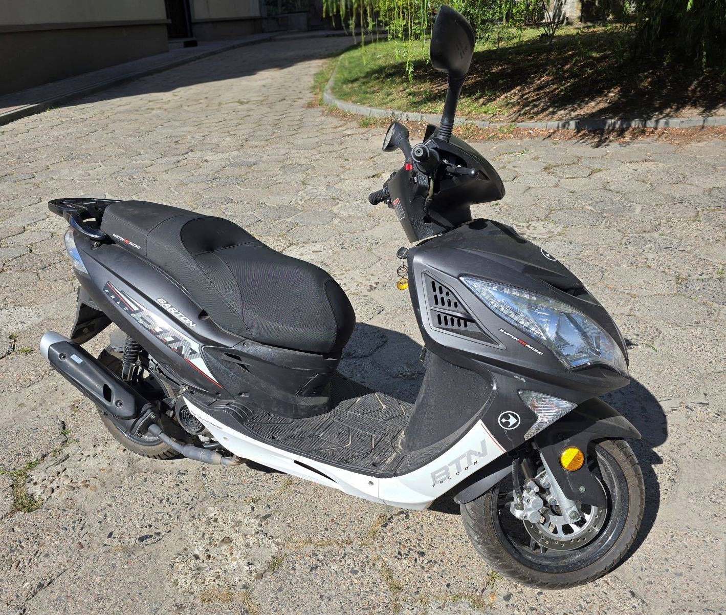 Widok motoroweru z prawej strony, z profilowaną kanapą i widocznymi logotypami na obudowie