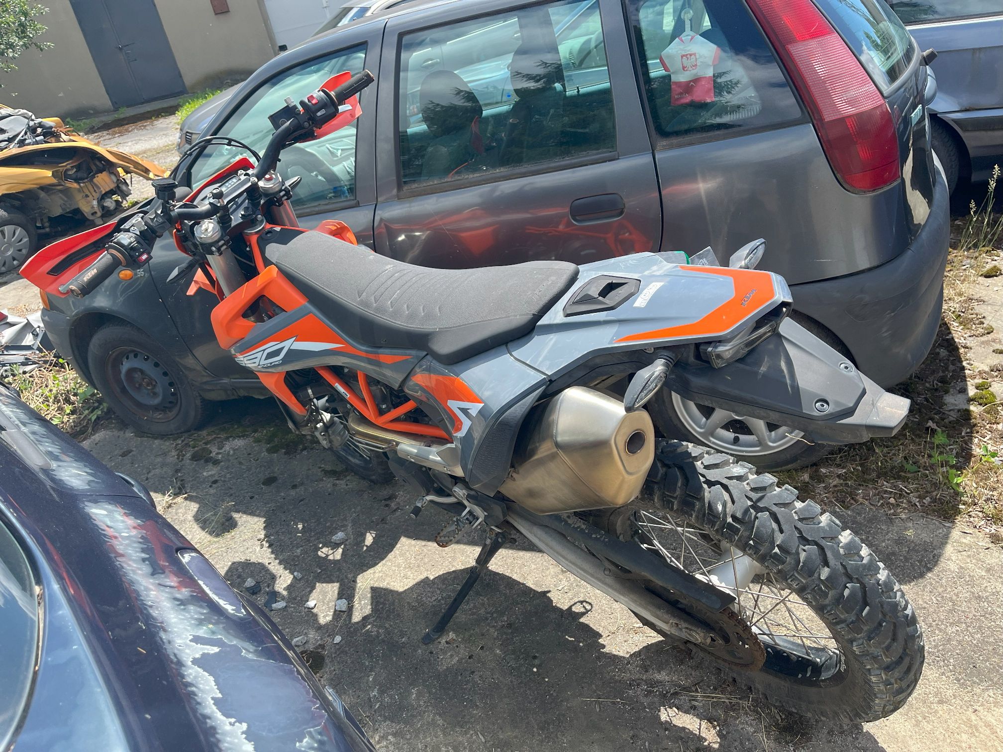 Lewy bok i tył motocykla z widocznymi terenowymi oponami, charakterystyczną ramą i wydechem
