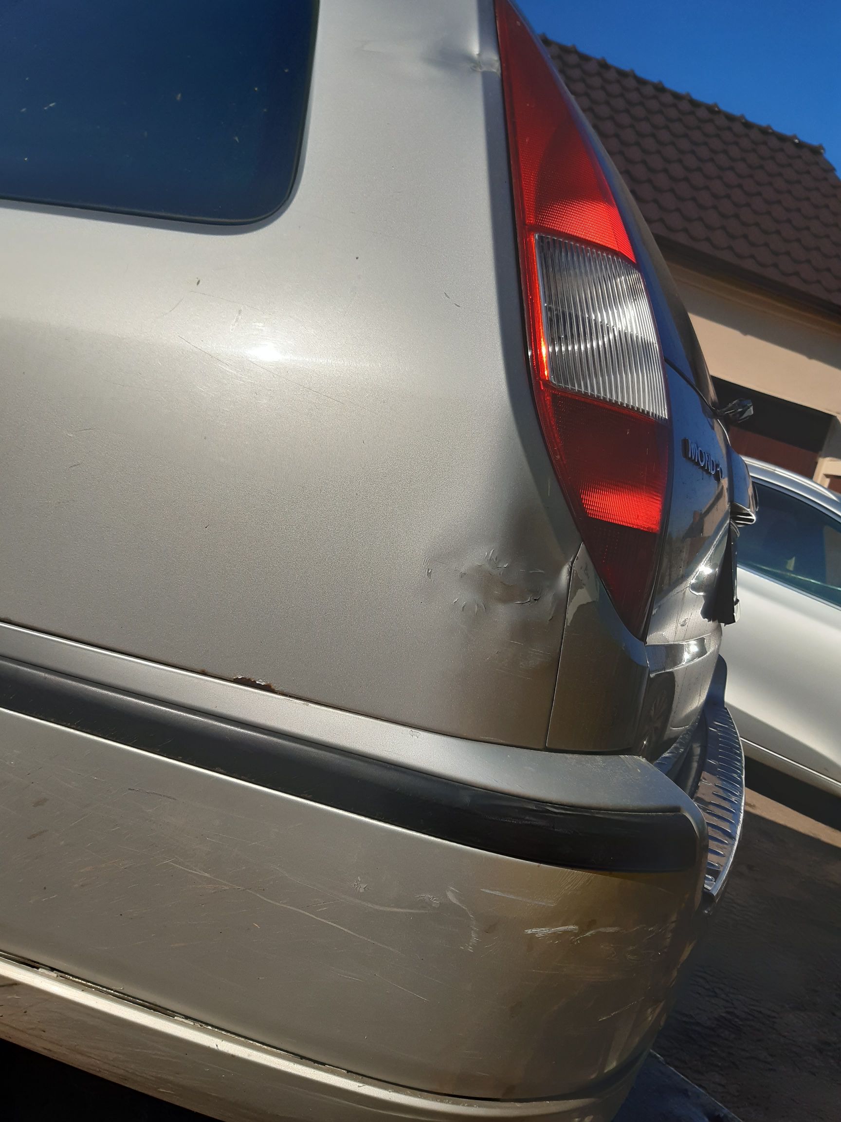 Ford Mondeo kombi ze srebrnym nadwoziem, wgnieceniem obok tylnej lampy i śladami rdzy na krawędzi