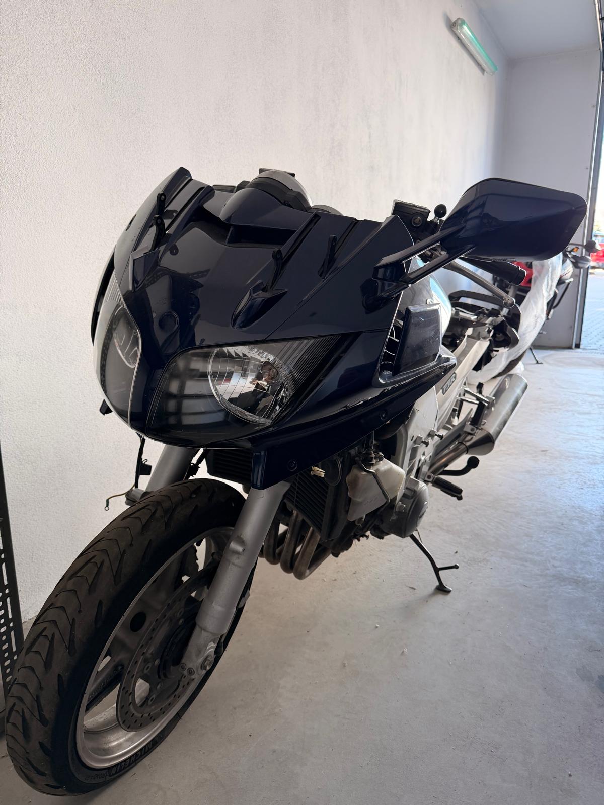 Przód granatowego motocykla Yamaha FJR. Pojazd zaparkowany w garażu.
