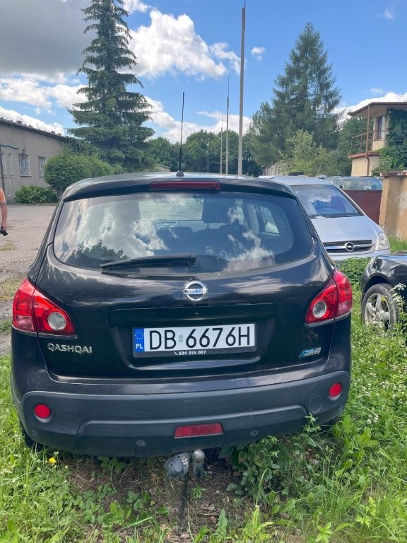 Tył pojazdu z widocznymi lampami, szybą i tablicą rejestracyjną