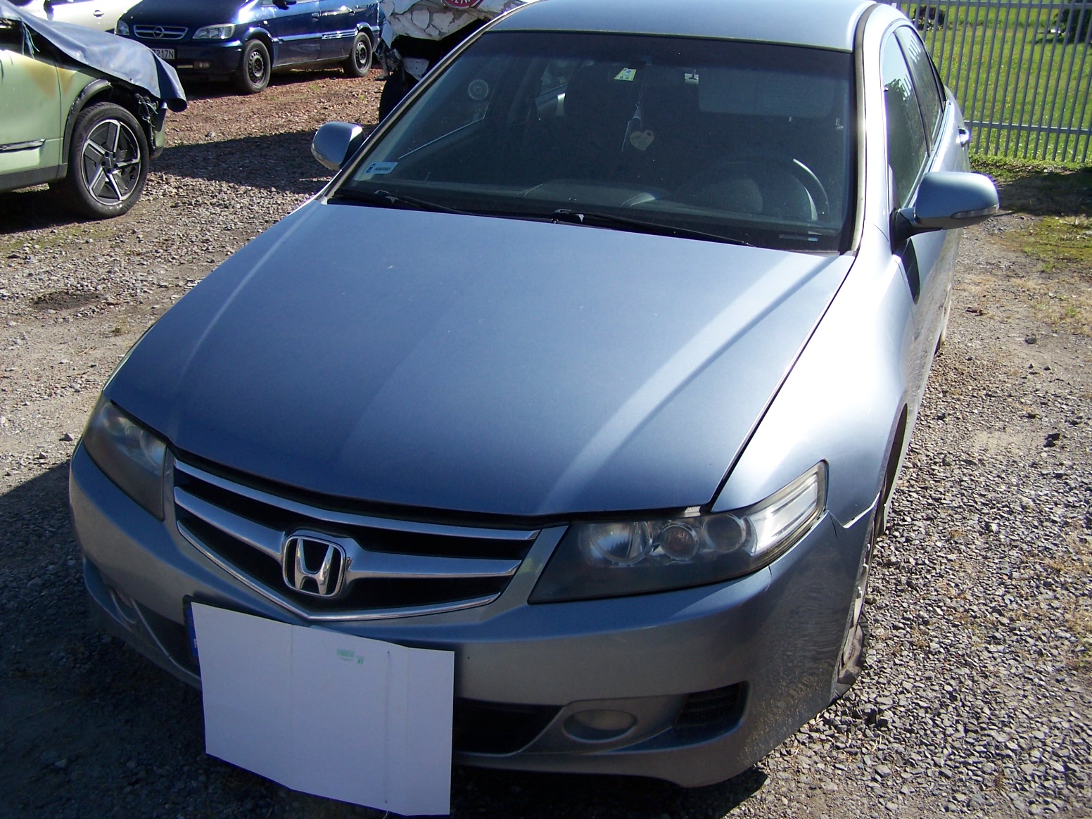 Zdjęcie przodu samochodu osobowego marki Honda Accord - Sedan, koloru srebrnego, przednie opony uszkodzone.