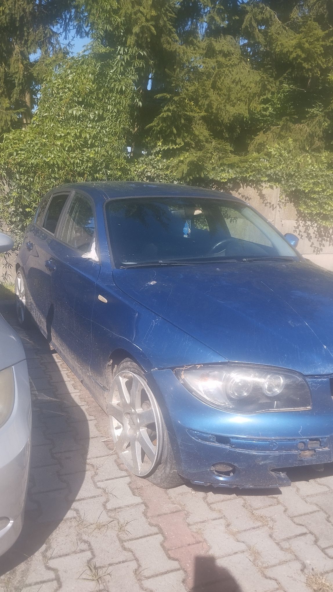 Niebieskie BMW widok maski i prawej strony pojazdu.
