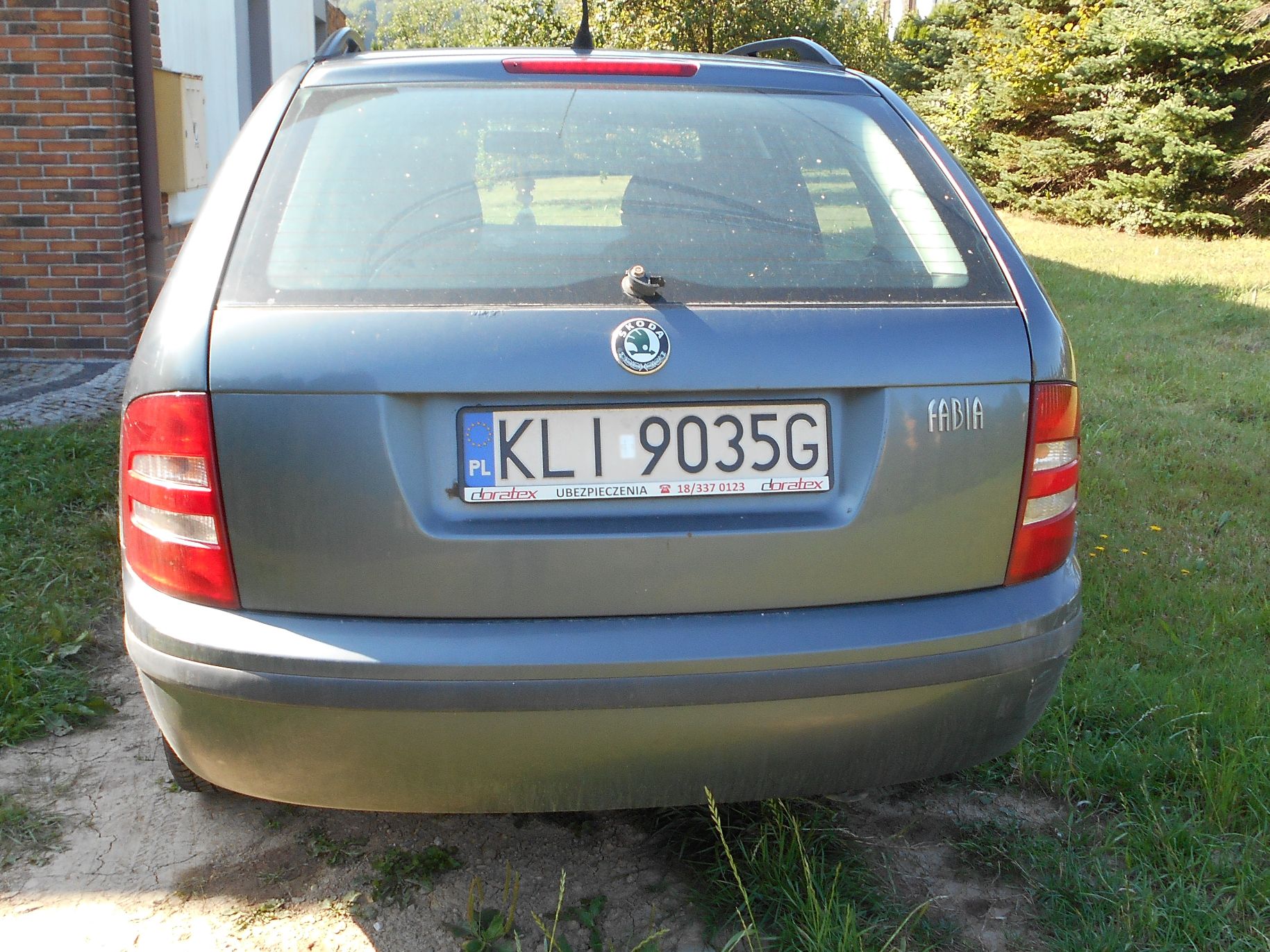 Tył zielonego samochodu osobowego marki Škoda Fabia.
