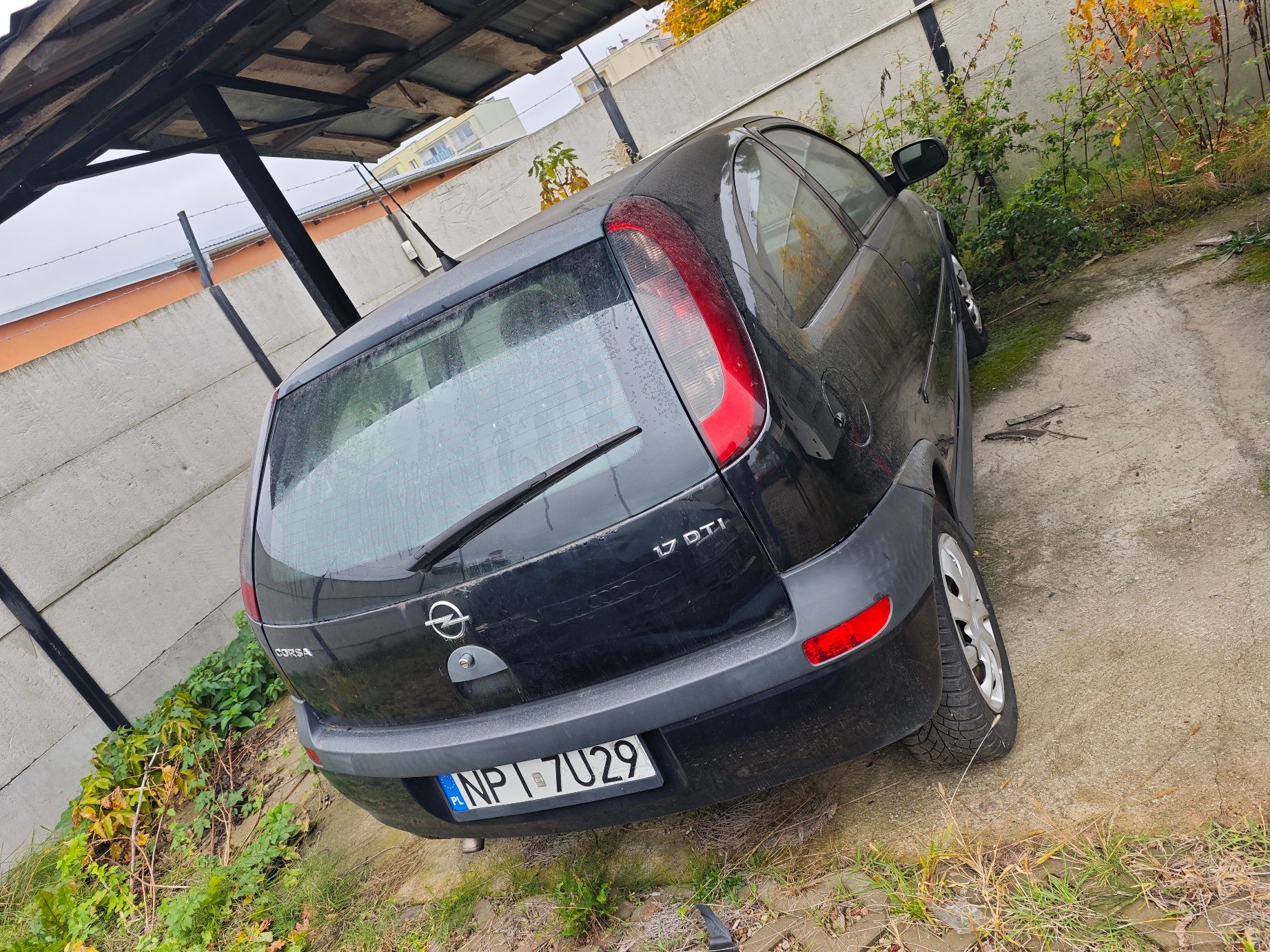 Tył czarnego samochodu Opel Corsa C z widoczną tablicą rejestracyjną NPI 7U29 i oznaczeniem silnika 1.7 DTI