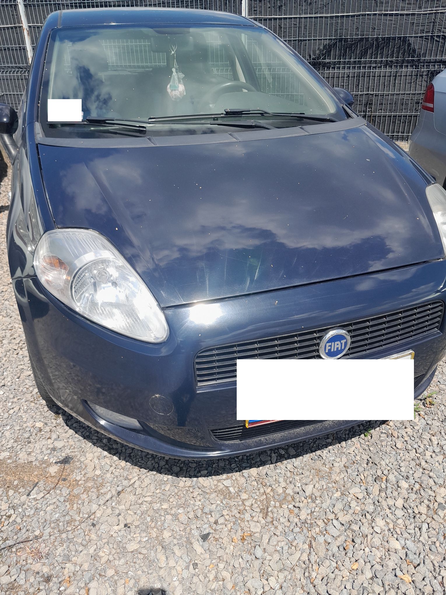 Granatowy Fiat Punto, widziany od przodu pojazdu