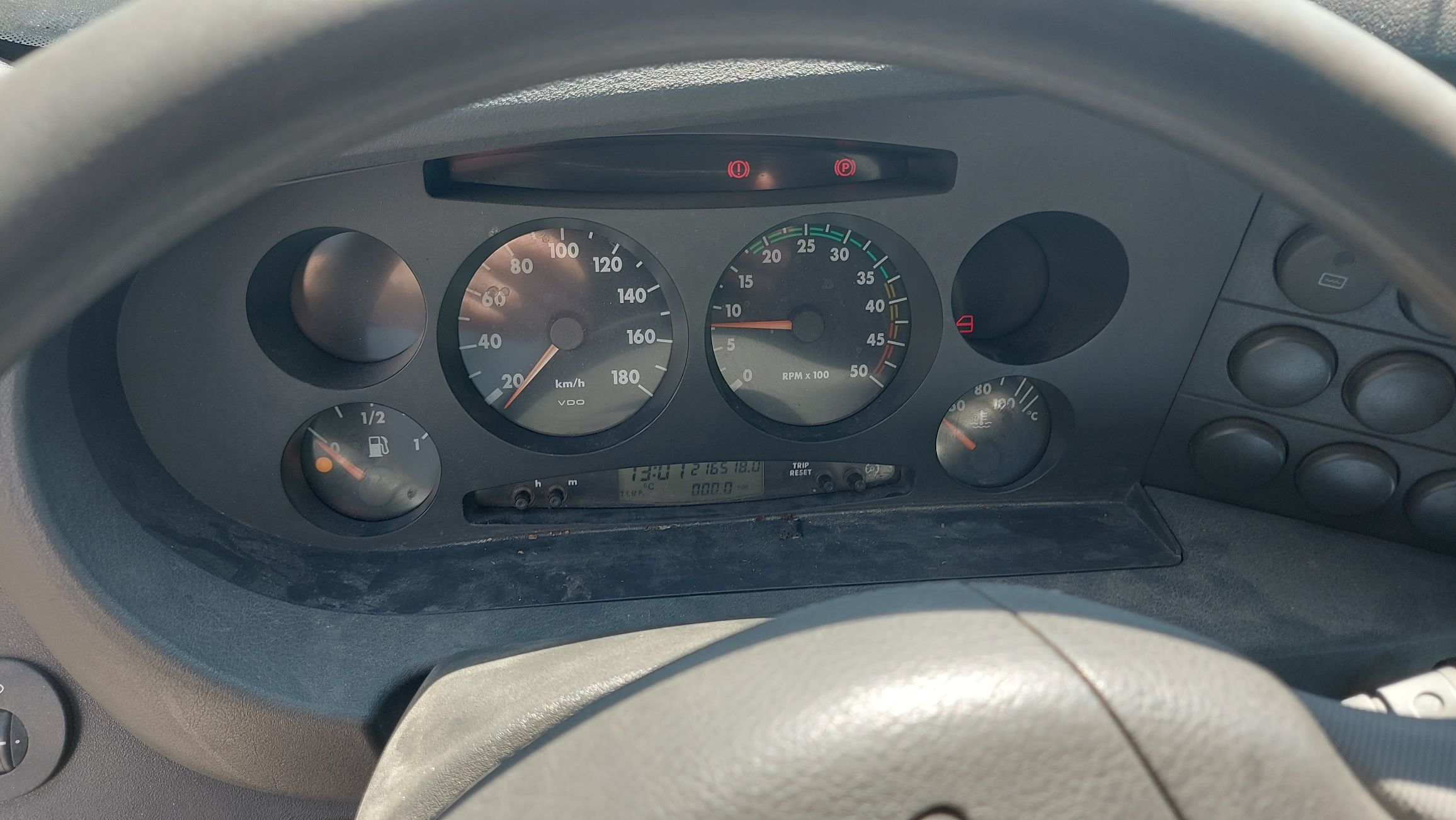 Zegary i wskaźniki na desce rozdzielczej Iveco Daily z aktywną kontrolką rezerwy paliwa. Wyświetlony przebieg 216 518 km.