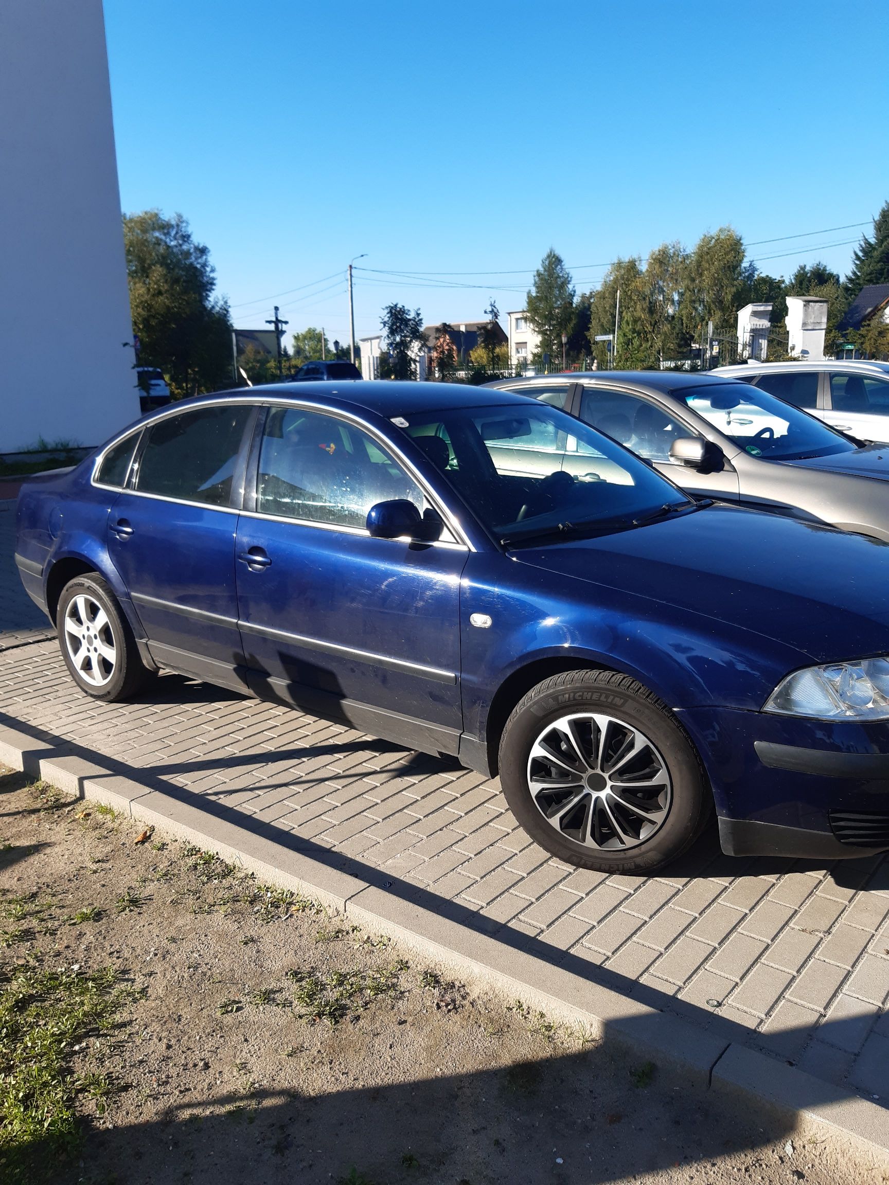 Bok granatowego sedana Volkswagen Passat B5 na czarno-srebrnych alufelgach, z widocznym przednim i tylnym kołem.