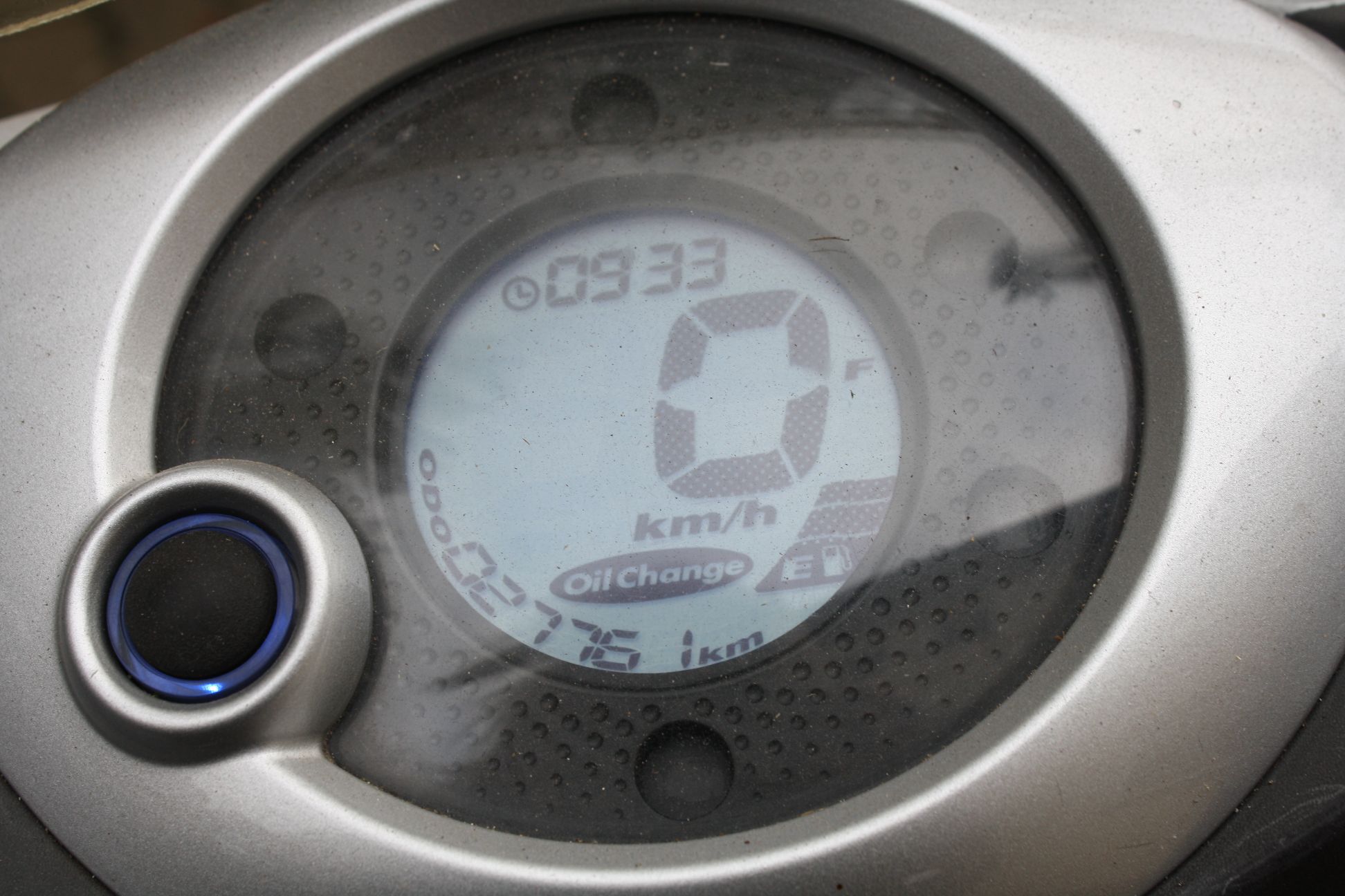 Zbliżenie na okrągły, analogowy licznik prędkości do motoroweru z chromowaną obudową.