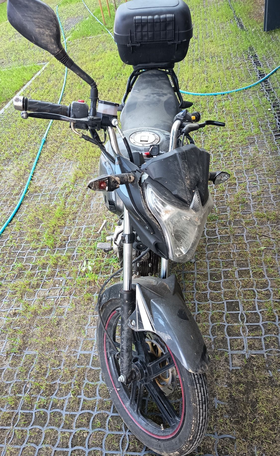 Zdjęcie przedstawia czarny motorower.