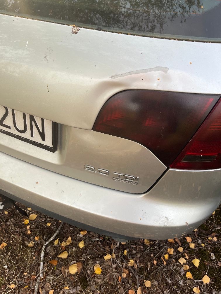 Zbliżenie na wgniecenie i korozję na tylnej klapie srebrnego Audi A4 B7.