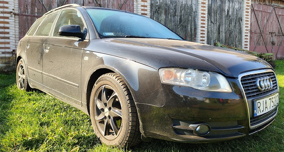 Samochód Audi A4 w kolorze czarnym widoczny od boku z lewej strony.