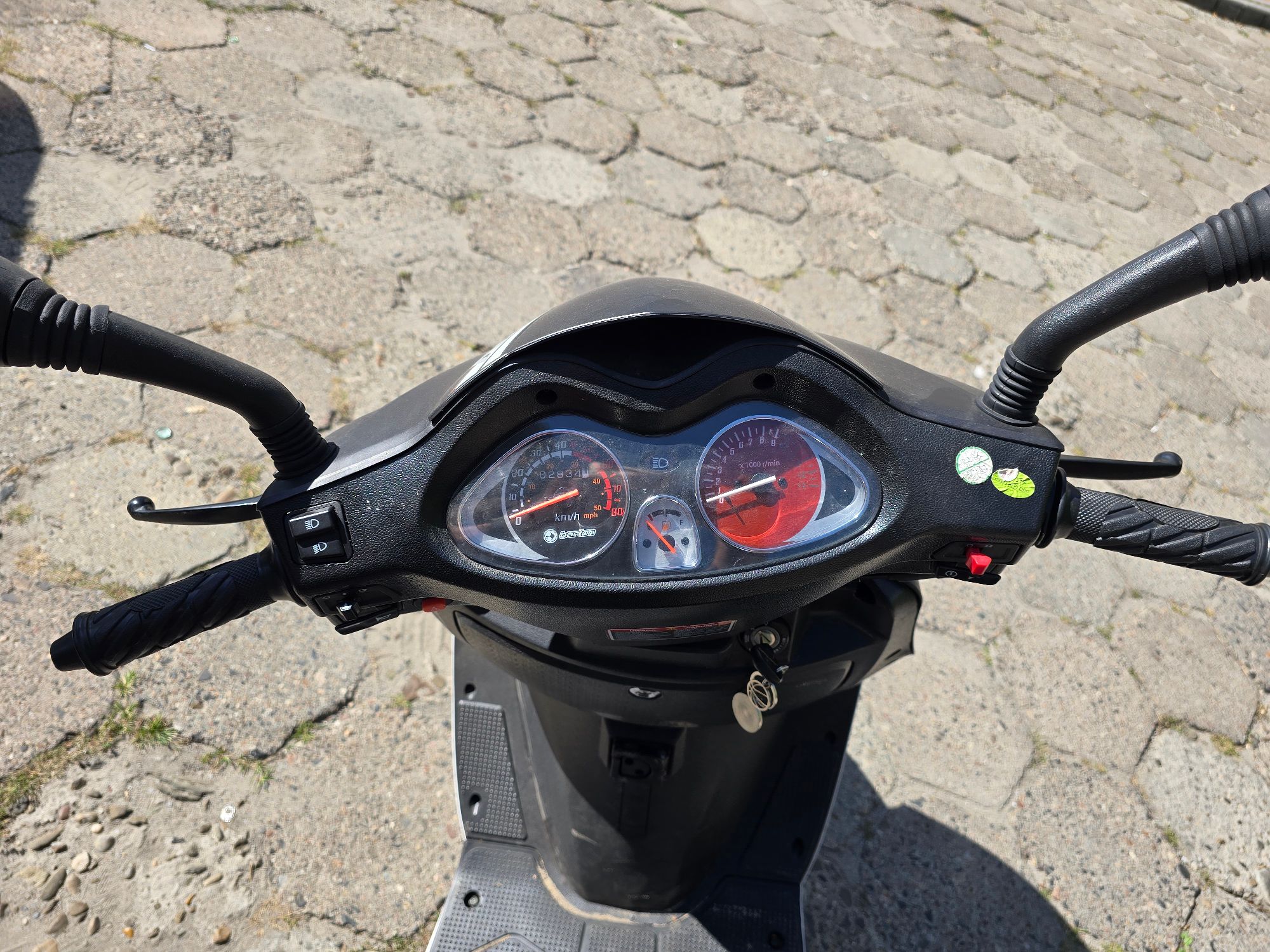 Widok kierownicy motoroweru wraz z kokpitem i zestawem wskaźników