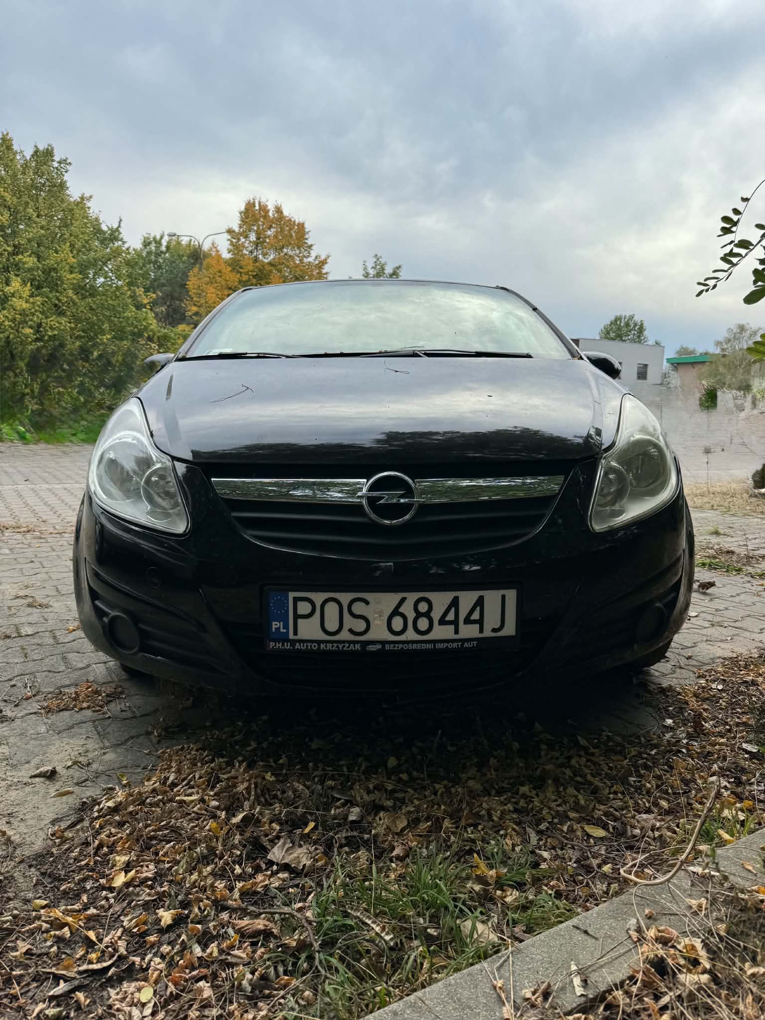 Zdjęcie przedstawia przód pojazdu. Karoseria w kolorze czarnym. Widoczny pęknięty zderzak.