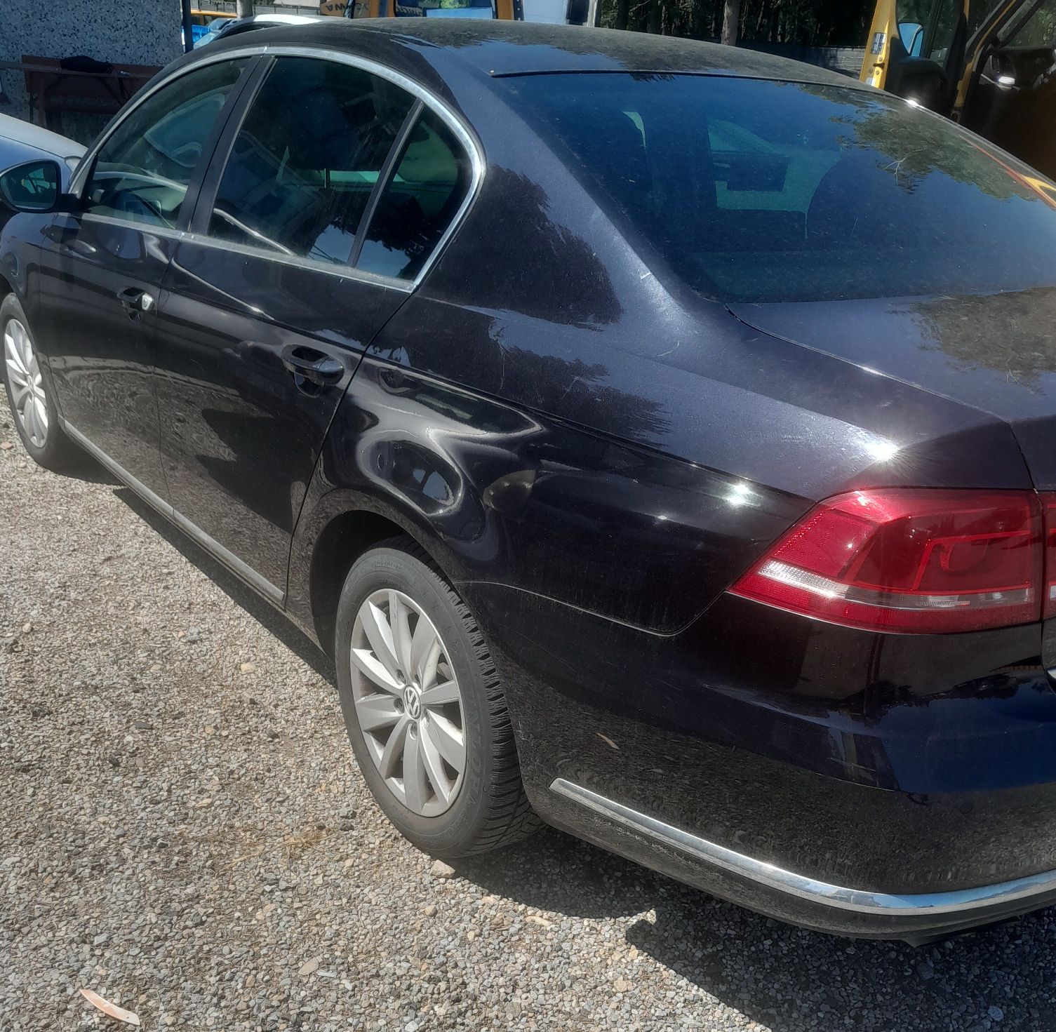 Czarny Volkswagen Passat, widziany od tyłu lewy bok pojazdu