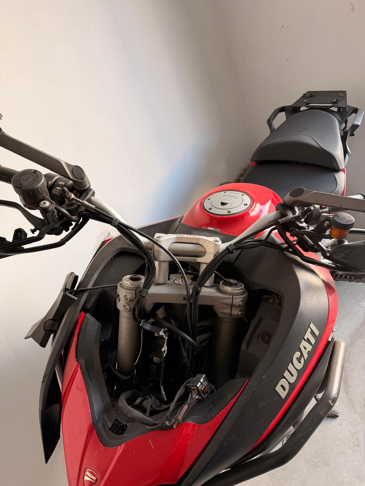 Czerwony motocykl Ducati Multistrada. Widok z góry, częściowo rozebrany, widoczny brak licznika.