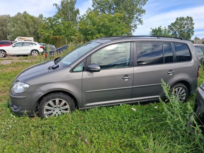 Szary samochód osobowy Volkswagen Touran w wersji minivan.