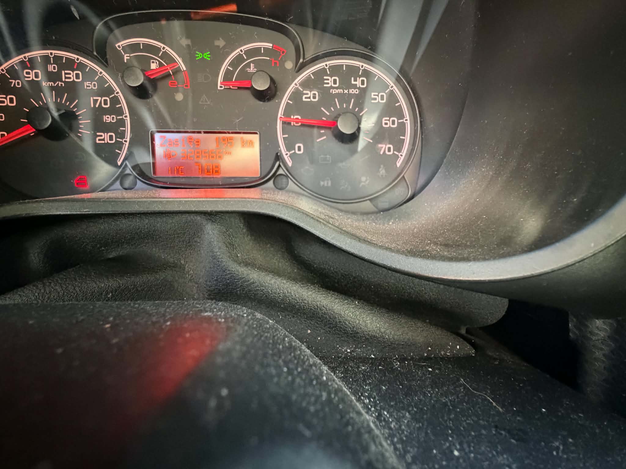 Fiat Doblo z 2010 roku o charakterystycznej bryle. Auto ma dużą przednią szybę, pionowe reflektory i przesuwne drzwi boczne.