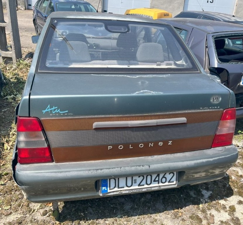 Tył pojazdu z uszkodzonym zderzakiem po stronie lewej, lakier zmatowiały, poszycie blacharskie z ogniskami korozji