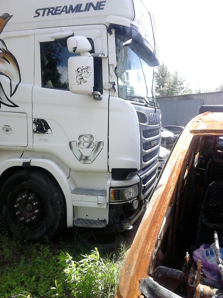 Ciężarówka w białym kolorze z czarno-białym motywem, stojąca na parkingu