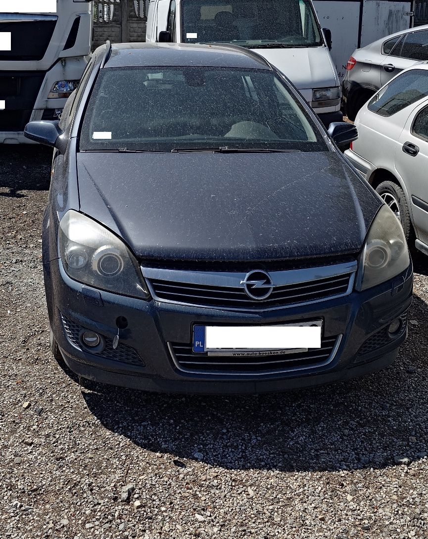 Granatowy osobowy Opel Astra widziany od przodu.