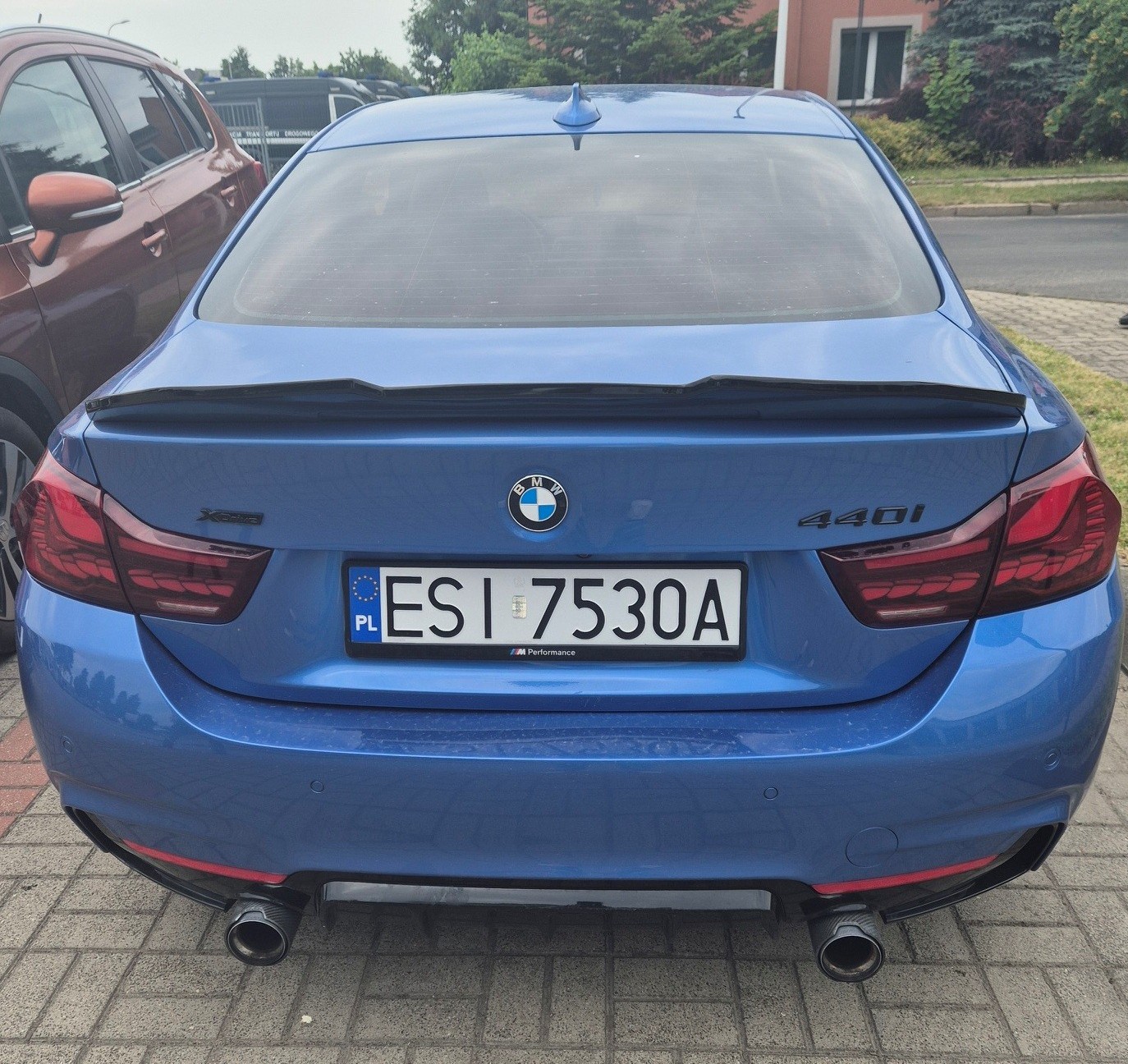 Niebieskie BMW z polską tablicą rejestracyjną, zdjęcie tyłu.
