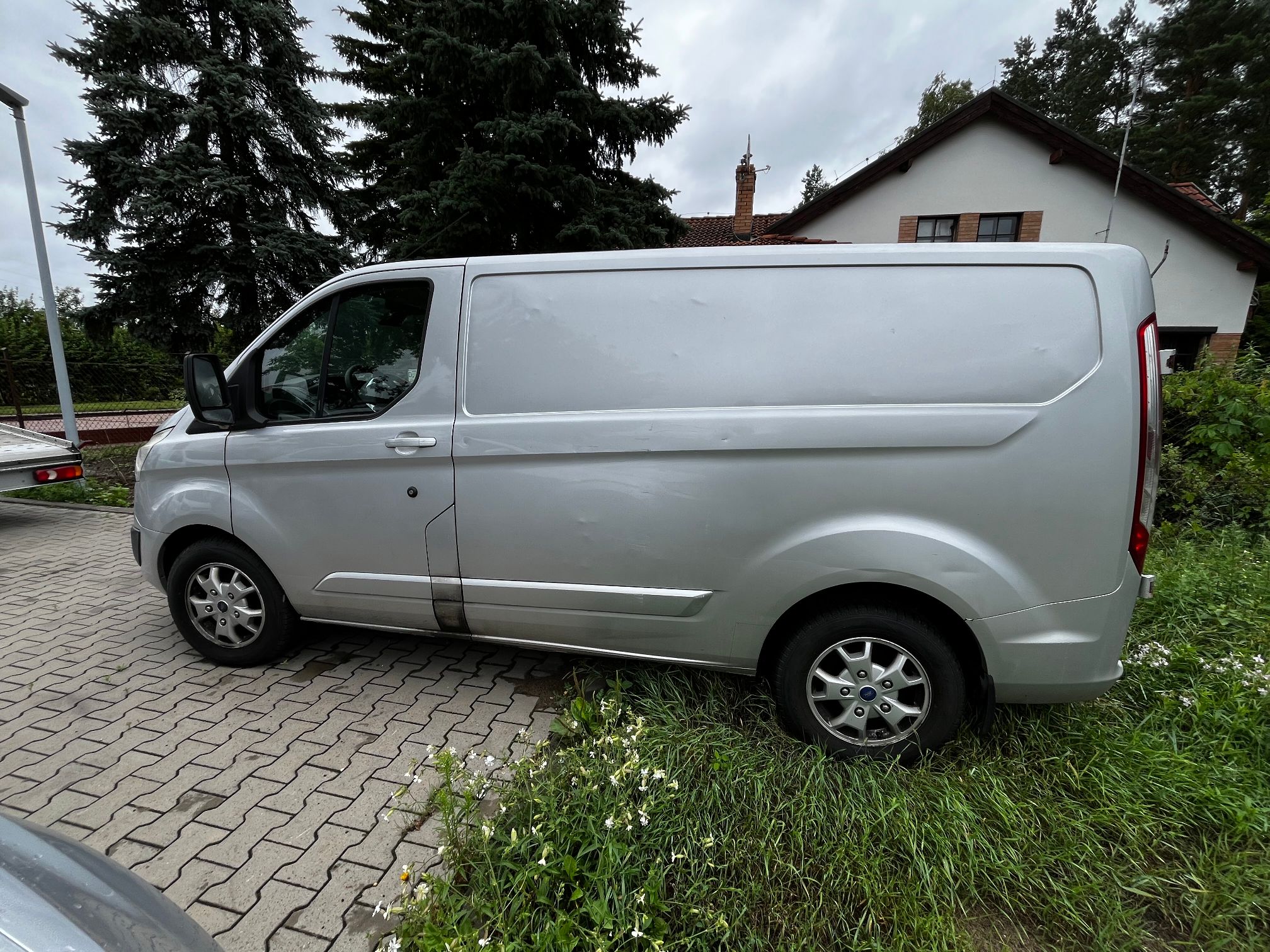 srebrny Ford Transit Custom widok boku pojazdu od strony kierowcy