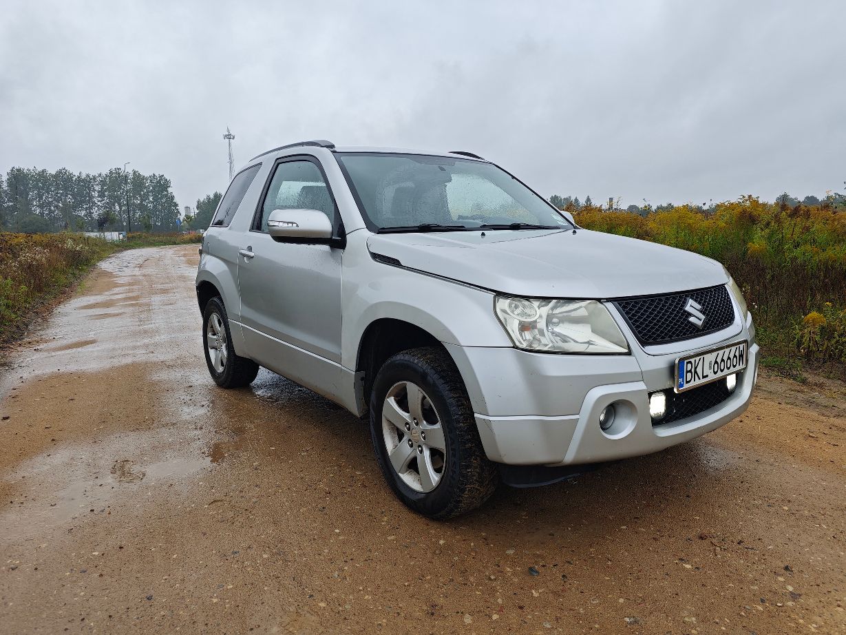 Srebrny samochód marki Suzuki Grand Vitara II w wersji trzydrzwiowej, prawa przednia strona