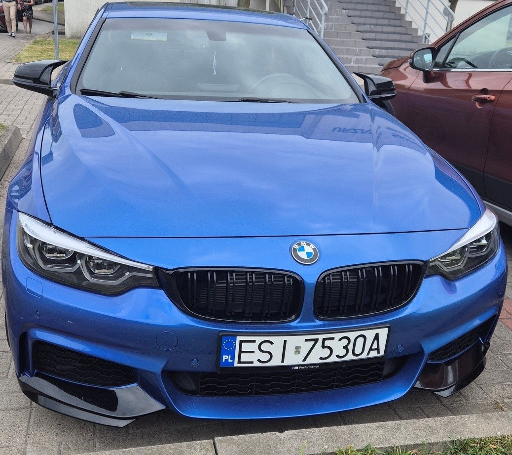 Niebieskie BMW z polską tablicą rejestracyjną, zdjęcie przodu.