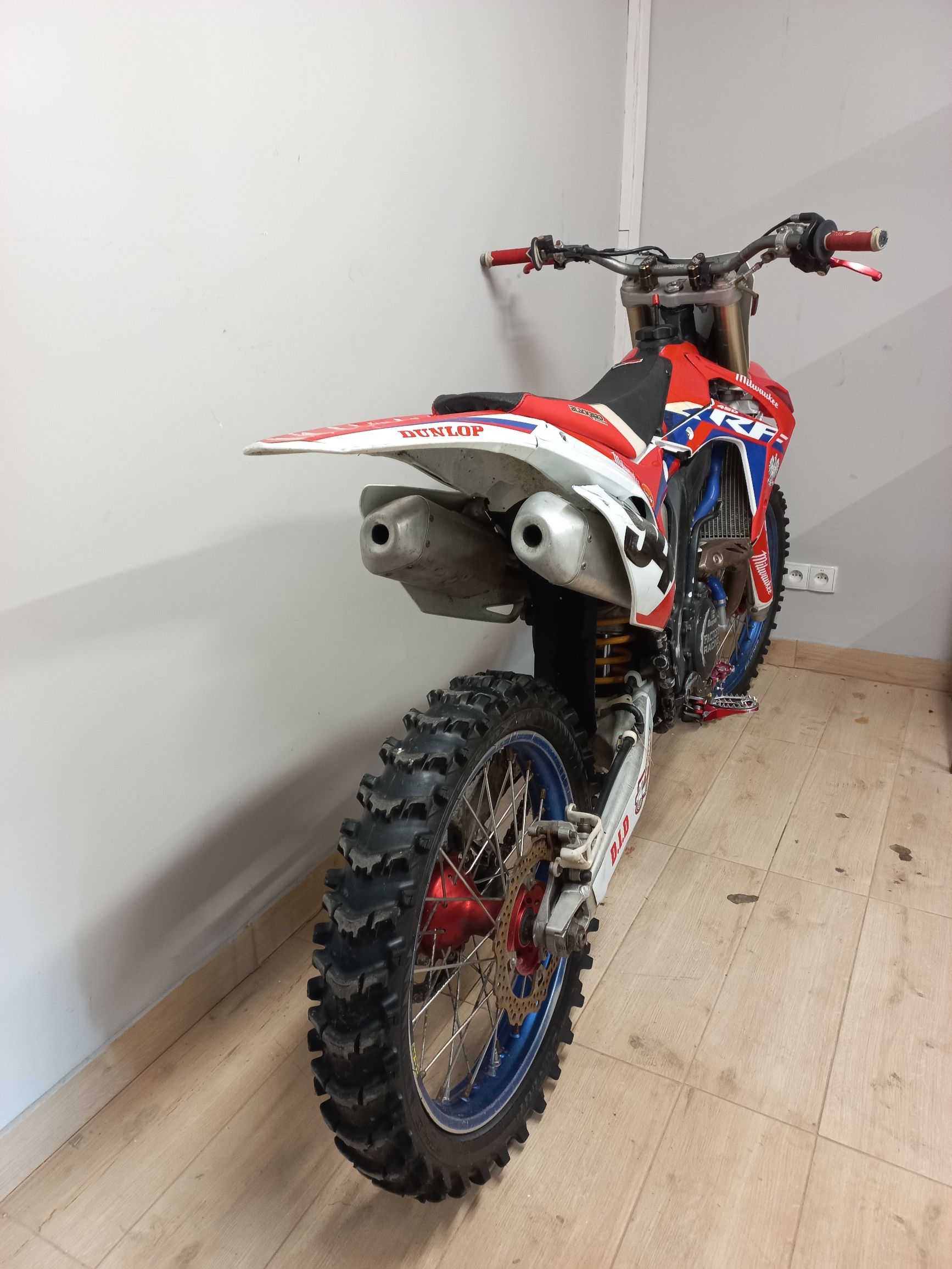 Widok od tyłu na motocykl crossowy Honda z podwójnym wydechem i oponą kostkową Dunlop