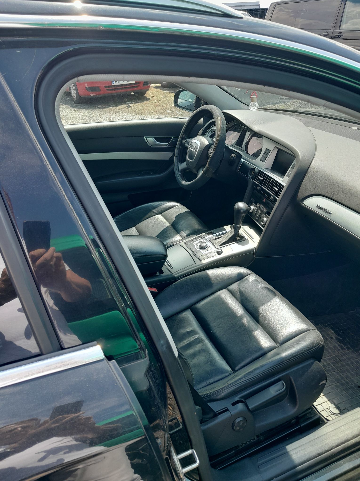 Wnętrze Audi A6, z czarnymi skórzanymi fotelami, kierownicą i deską rozdzielczą