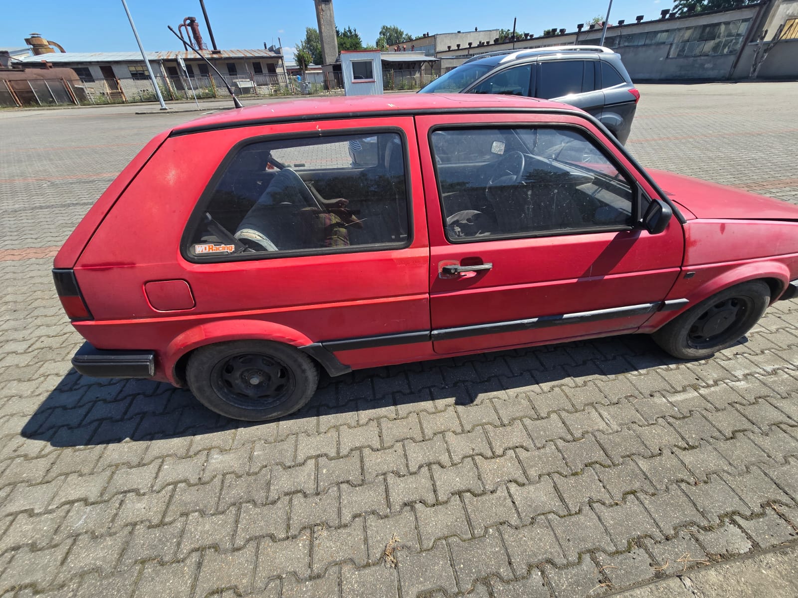 Zdjęcie prawego boku pojazdu, maska przednia lekko podniesiona, nadkola przednie mają wyblakły kolor