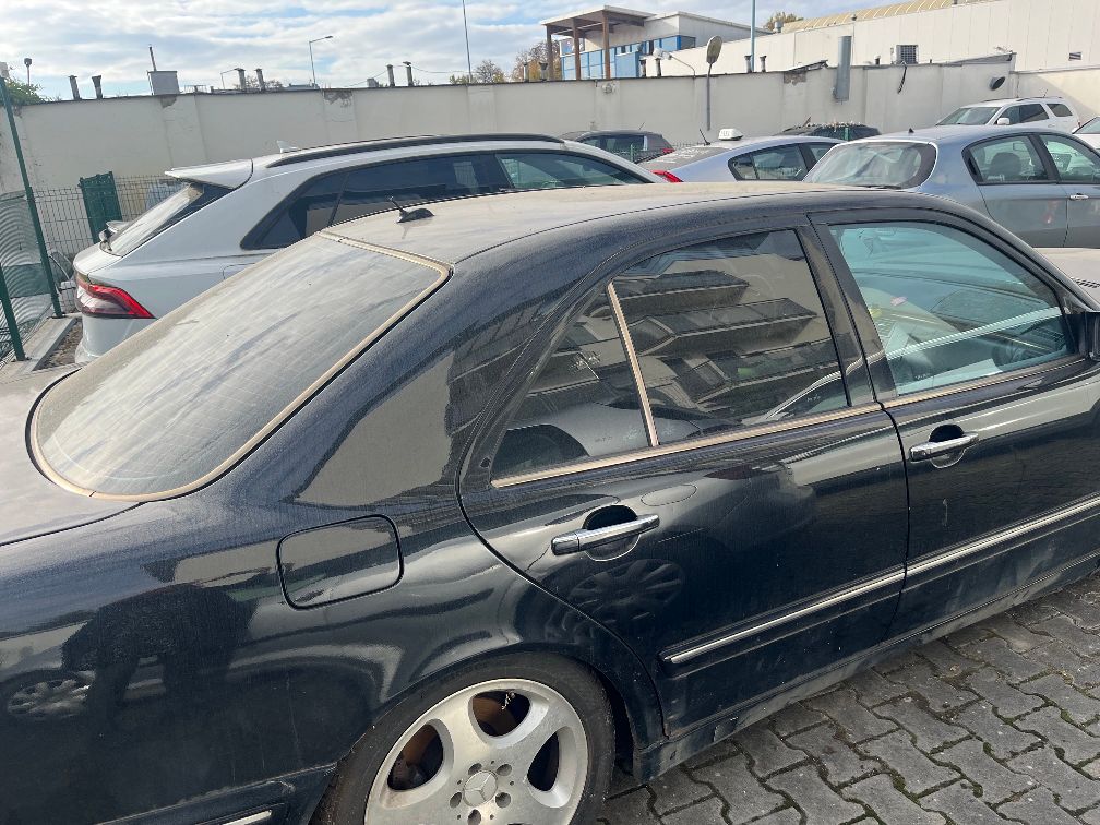 Profil boczny czarnego sedana Mercedes-Benz.
