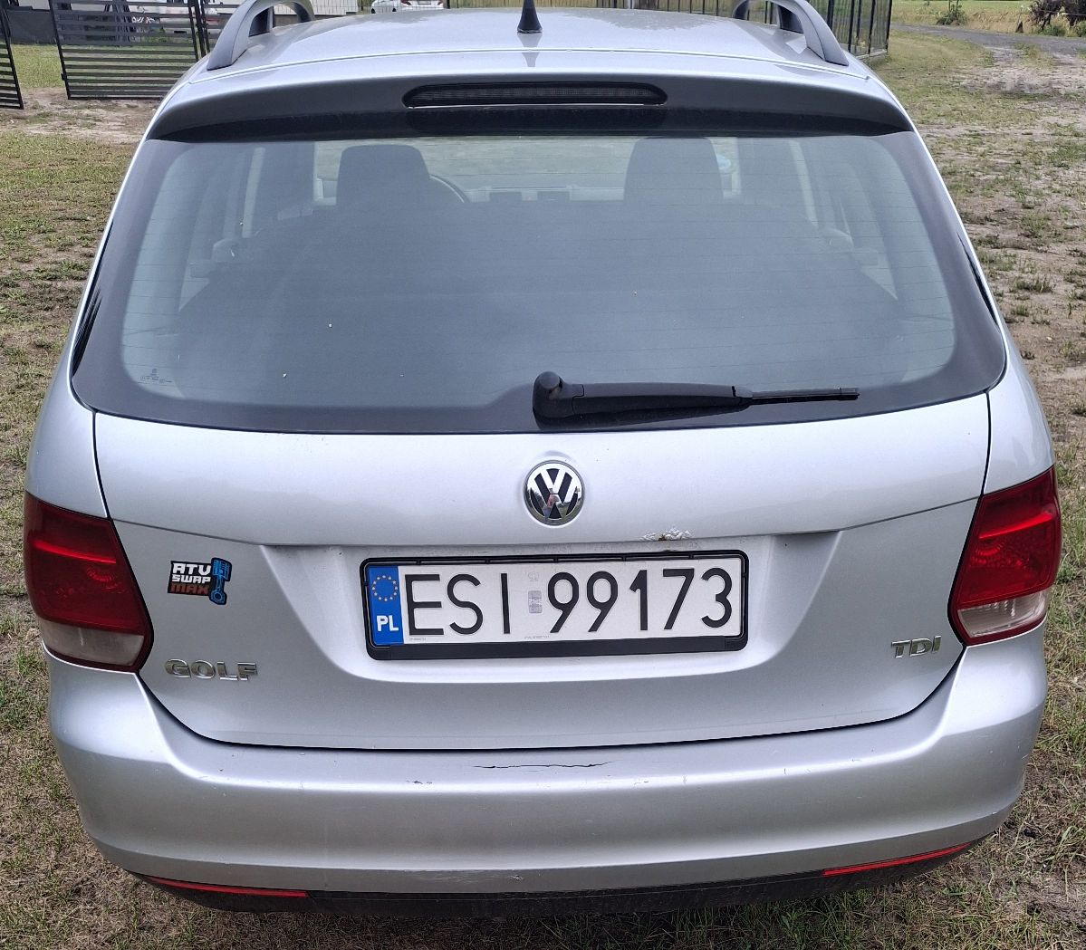 Tył srebrnego Volkswagena Golfa kombi z polską tablicą rejestracyjną, widoczne napisy GOLF, TDI oraz naklejka po lewej stronie.