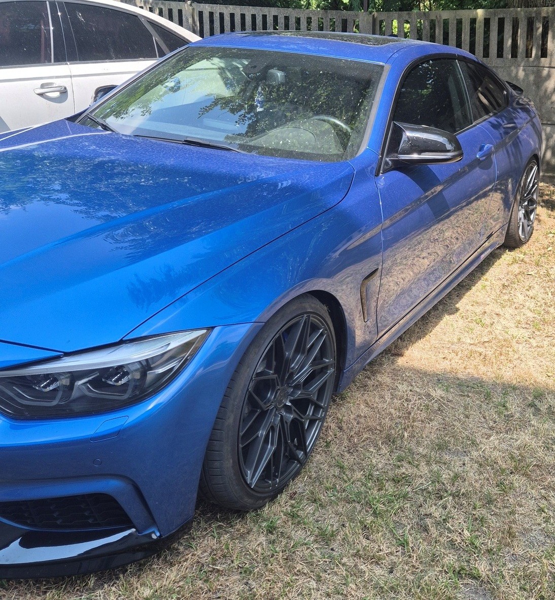 Niebieskie BMW z polską tablicą rejestracyjną, zdjęcie przód lewego profilu.